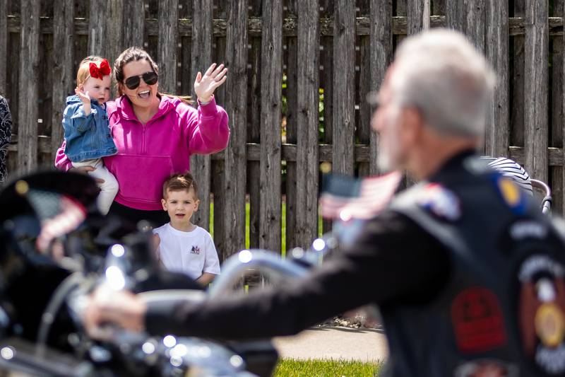 Shorewood resident Bridget Stewart, and her children Lyla and Beckham, wave as members of the Plainfield American Legion Riders participate in the Memorial Day Parade in Plainfield on May, 26, 2025.