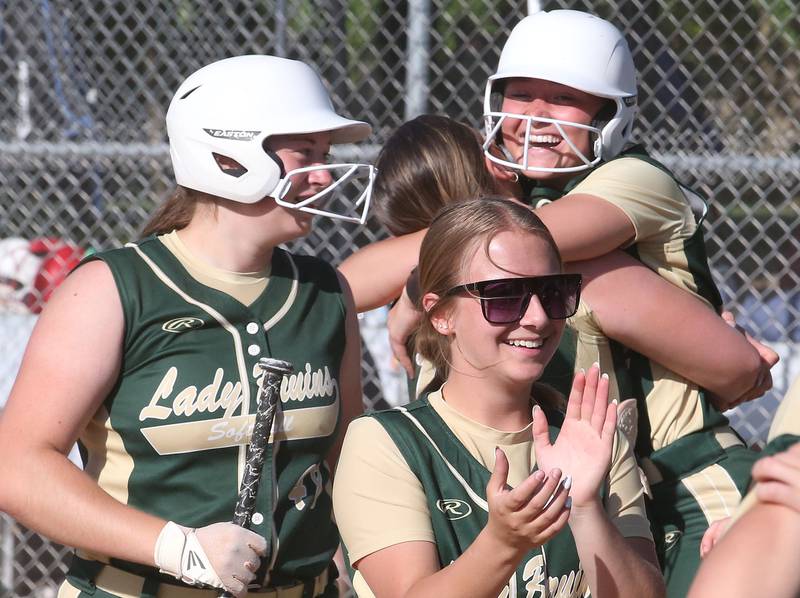 St. Bede's Ella Hermes (top) hugs teammate Bella Pinter after hitting a three-run home run as other teammates Reagan Stoudt and Bailey Engles smile in the Class 3A Sectional championship game on Friday, May 26, 2023 at St. Bede Academy.