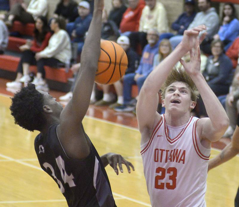 Ottawa’s Owen Sanders and Kaneland’s Jeffrey Hassan battle for a loose rebound in the 1st quarter Tuesday at Ottawa.
