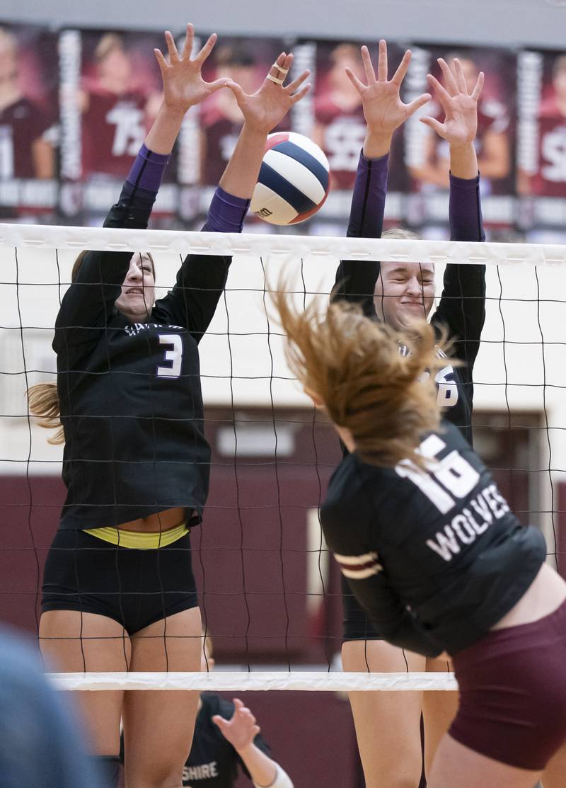 Hampshire's Lily Ingve, left, and Anna Schiltz, attempt a block as Prairie Ridge's Addy Grider spikes the ball between them during their game on Thursday, October 2, 2025 at Prairie Ridge High School in Crystal Lake. Ryan Rayburn for Shaw Local