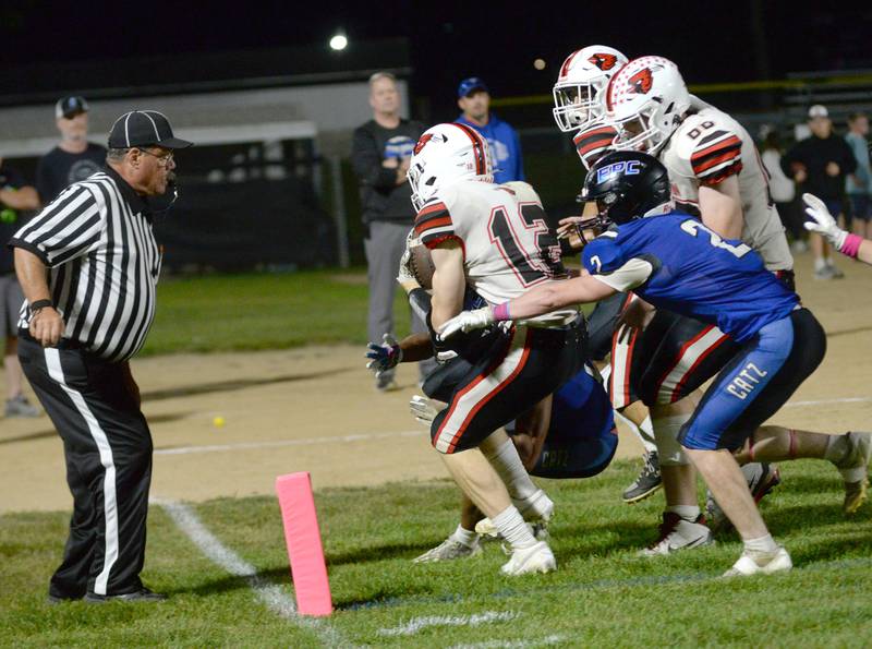 Forreston's Eli Faris (12) fights his way into the end zone as Eastland-Pearl City's Sawyer Williams (2) tries to stop him at during a game at Pearl City High School on Friday, Oct. 3, 2025.