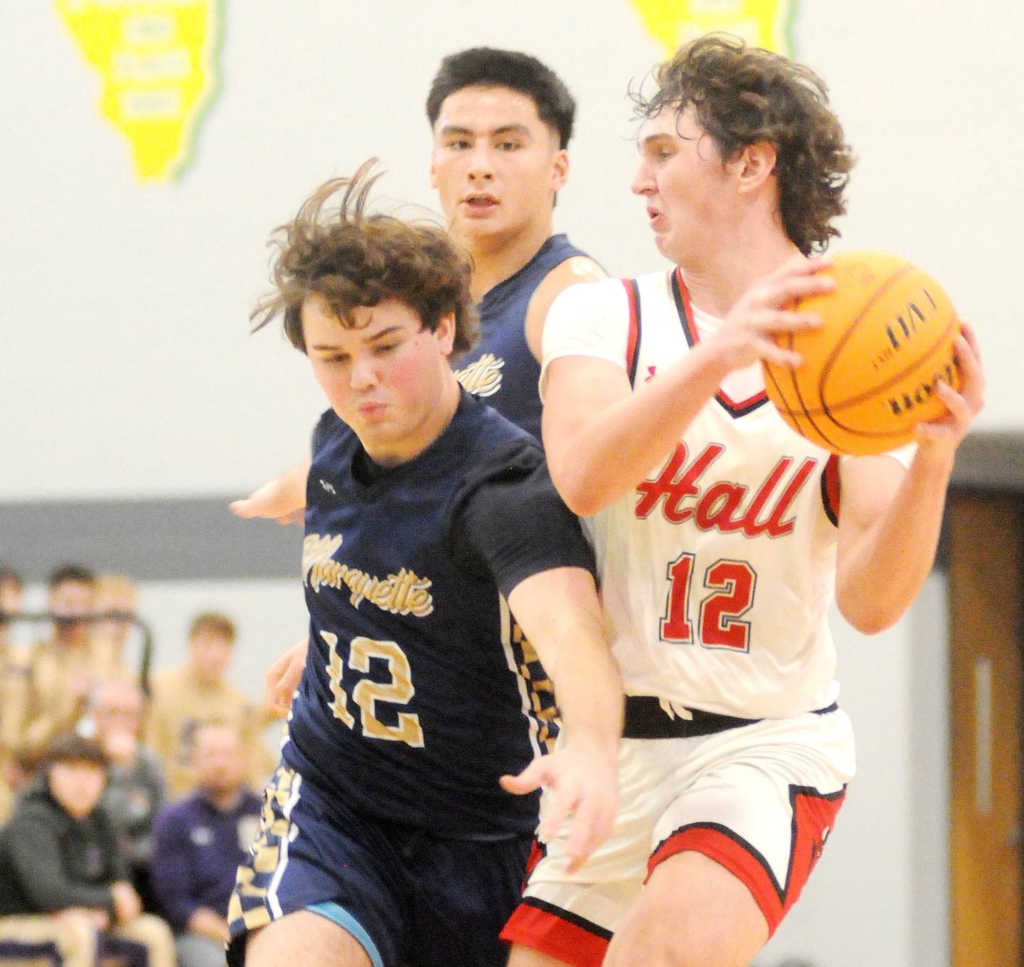 Hall's Jack Jablonski passes past Marquette's Ashton Grady on Thursday, Dec. 26, 2024, at Seneca High School.