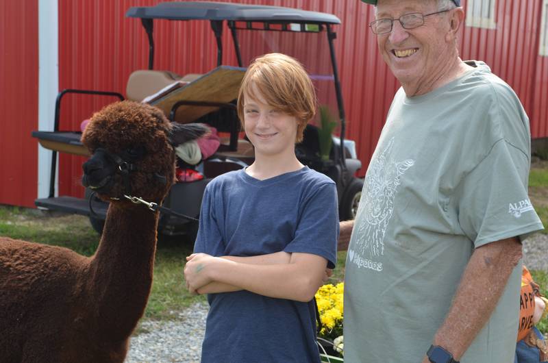 Randy Larson, right, and Aaron Bush of Morrison, pose with Oo-la-la at Larson's farm west of Morrison on Saturday.