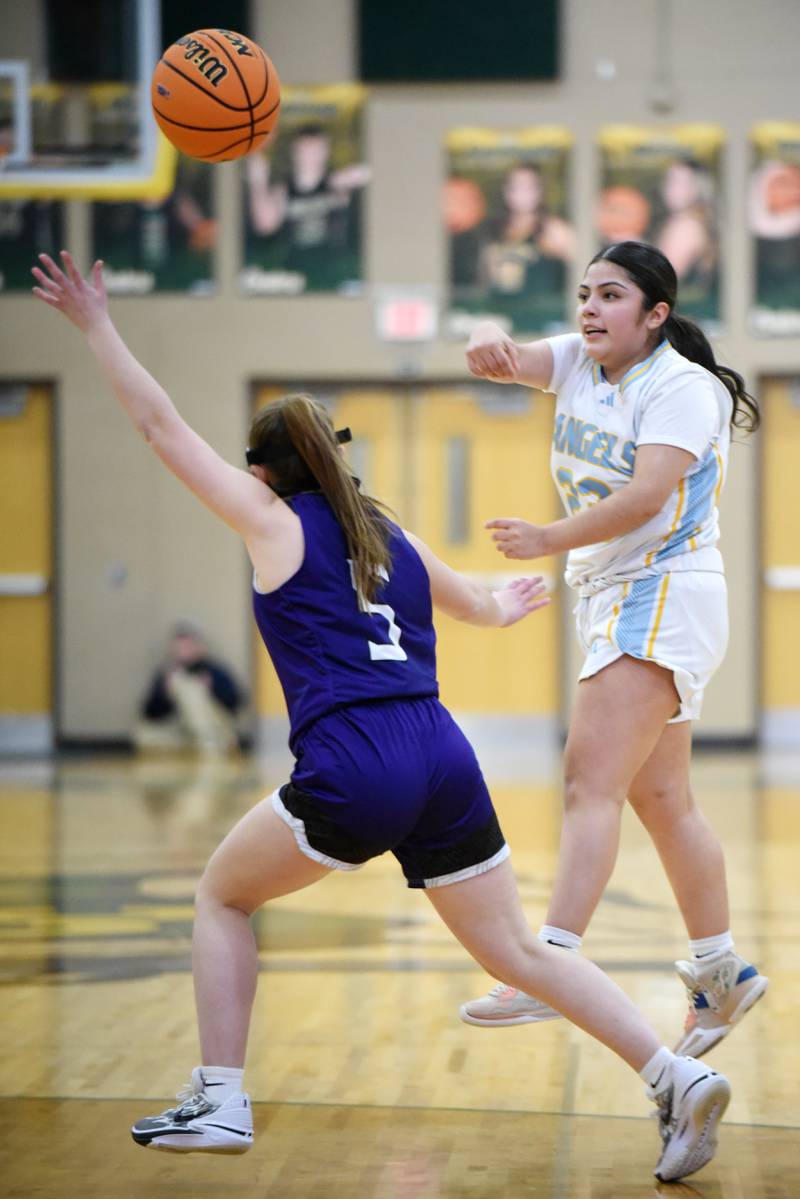 Joliet Catholic Academy's Breeanna Zafra, right, throws a pass over Wilmington's Alaina Clark during an IHSA Class 2A Coal City Regional semifinal Tuesday, Feb. 18, 2025.