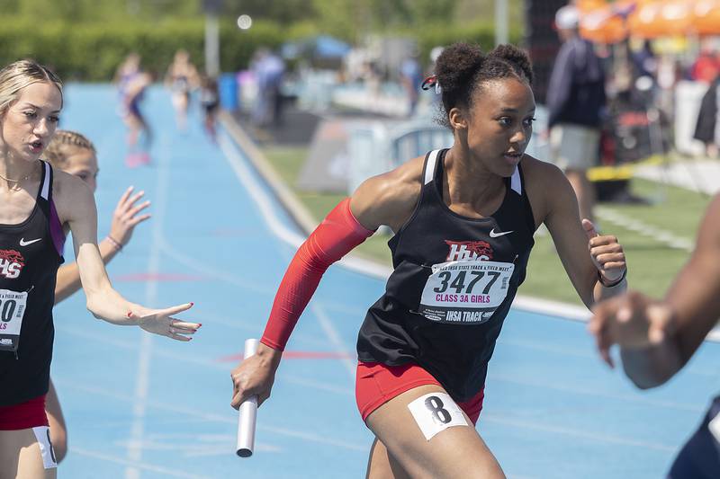 Huntley’s Dominique Johnson takes the baton Sophia Amin the the 3A 4x200 race Saturday, May 20, 2023 during the IHSA state track and field finals at Eastern Illinois University in Charleston.