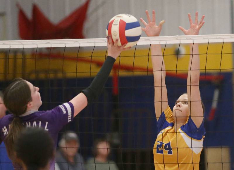 Logan's Allison Cihocki blocks a spike from Rockford-Marshall's Ashlyn Tingley during the IESA Class 3A eighth-grade Regional final game on Thursday, March 13, 2025 at Logan Junior High School in Princeton.