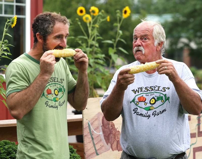 Wessels' Family Farm owners Rob Wessels (right) and his son Brandon enjoy some of their sweet corn Tuesday, Aug. 19, 2025, at Wessels' Family Farm Market in DeKalb. They are preparing to be a big part of  this weekend’s Corn Fest.