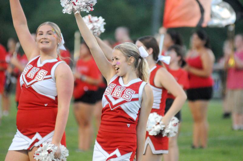 Cheerleaders perform with the band before the game against East Peoria at Deiken Stadium on Friday, Aug. 25, 2023.