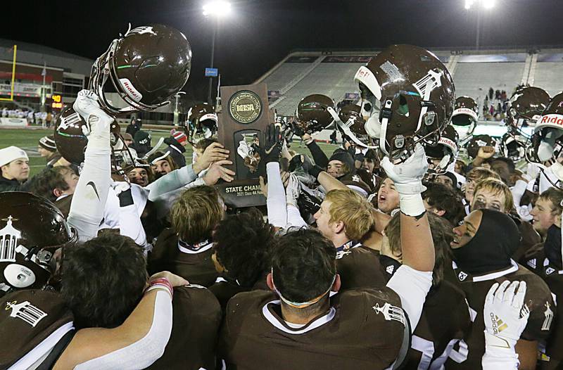 Members of the Joliet Catholic football team hoist the Class 4A first-place state trophy after defeating Springfield (Sacred Heart-Griffin) 56-27 in the Class 4A state title game at Huskie Stadium on Friday Nov. 26, 2021 in Dekalb.