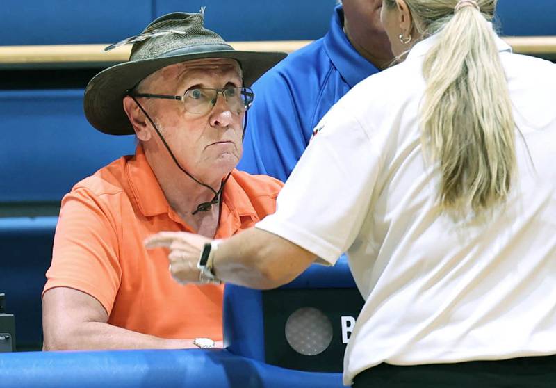 U.S. Navy veteran Jim Kush talks to an official Tuesday, Sept. 5, 2023, at Genoa-Kingston High School in his capacity as official score keeper for the Genoa-Kingston volleyball team. Kush also has sung the national anthem at Genoa-Kingston sporting events.