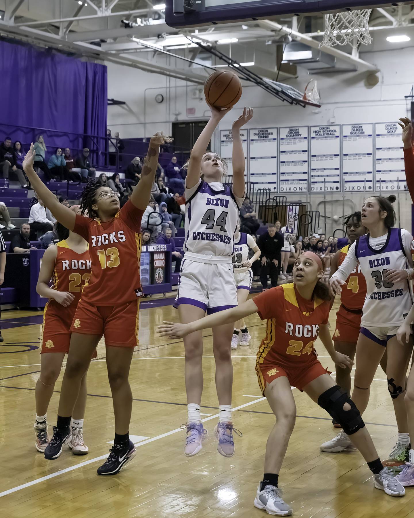 Dixon's Ella Govig shoots between Rock Island's DaNaijah Cartwright (13) and Danee Robinson during their Class 3A Dixon Regional semifinal Tuesday, Feb. 14, 2023 at Lancaster Gym.