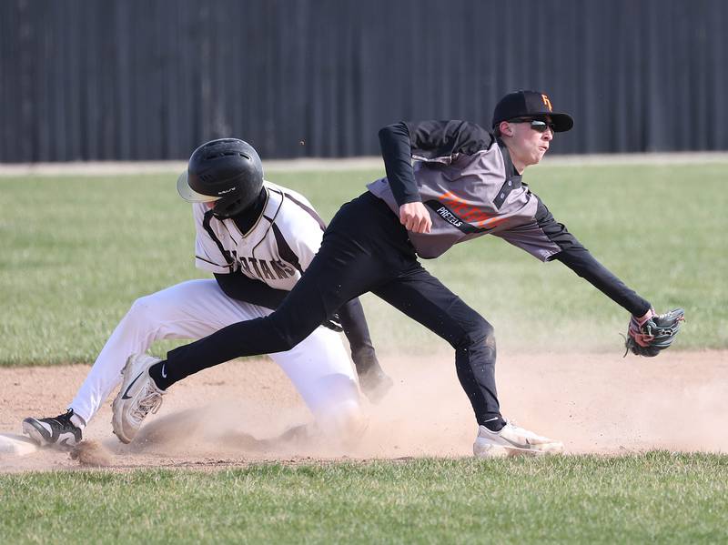Sycamore's Benjamin Anderson slides in safely with a stolen base as Freeport's Lathan Beach makes a play on the ball Tuesday, April 7, 2026, during their game at the Sycamore Community Sports Complex.