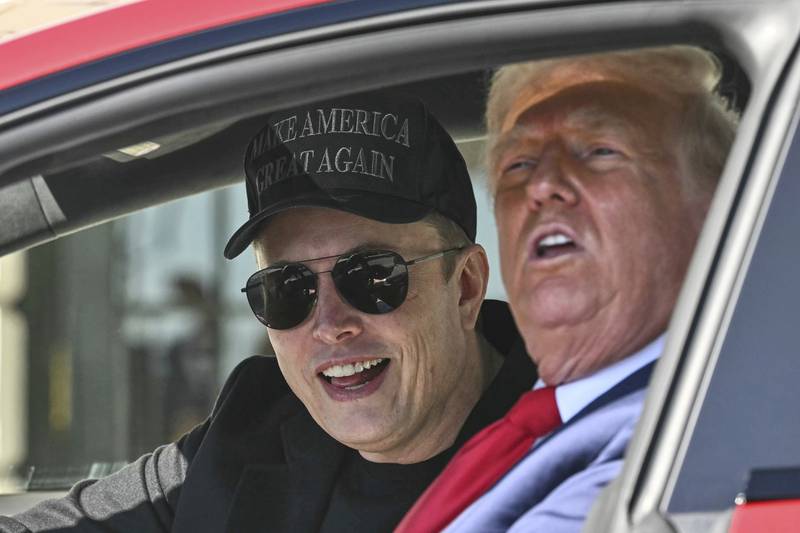 President Donald Trump and Tesla CEO Elon Musk speak to reporters as they sit in a Tesla vehicle on the South Lawn of the White House on March 11 in Washington.