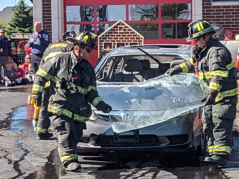 Firefighters with the Oswego Fire Protection District remove the windshield from a car as part of a vehicle extrication demonstration during a joint safety campus open house between the Oswego Fire Protection District and the Oswego Police Department on Oct. 11, 2025.