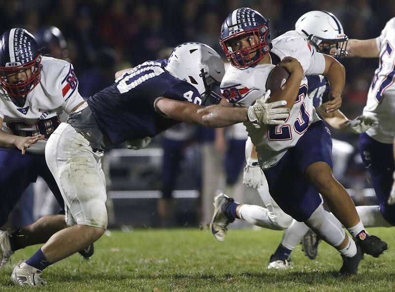 Cary-Grove's Logan Abrams tries to tackle Belvidere North's Zavian McElroy during an IHSA Class 5A quarterfinal playoff football game on Friday, November 14, 2025, at Cary-Grove High School, in Cary.