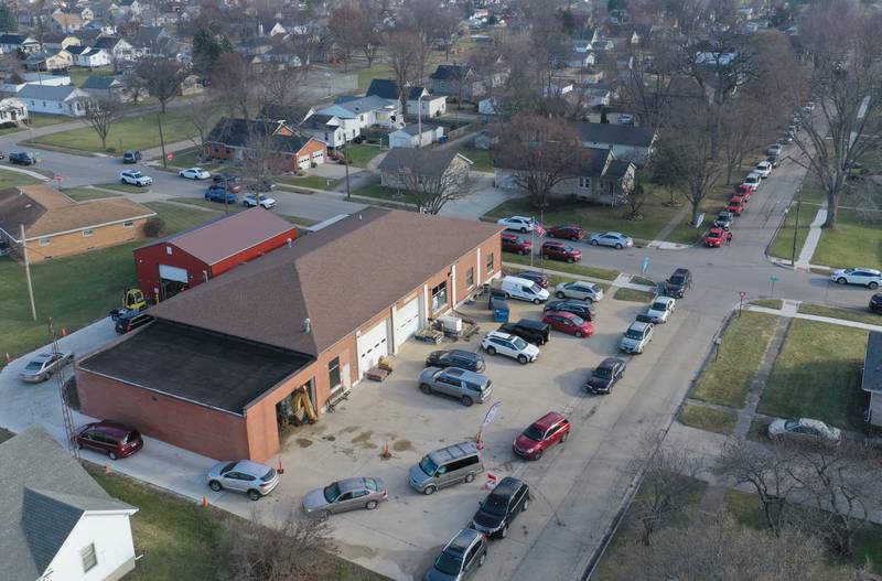 A long line of cars wraps around the Hall Township Food Pantry building for the Christmas distribution on Wednesday, Dec. 18, 2024 in Spring Valley.