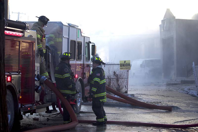 Joliet firefighters at the scene of a fire at an old commercial building on Thursday, Jan. 29, 2026, at the corner of South Eastern Avenue and Washington Street in Joliet.