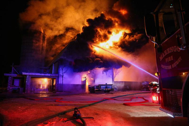 Firefighters work on controlling a barn fire at the 10800 block of Carls Road near Marengo in the early hours of Christmas Eve.