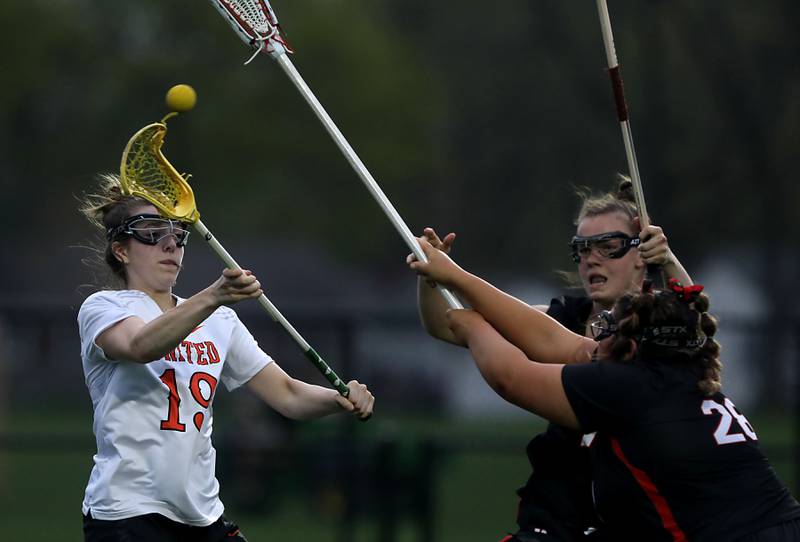 Crystal Lake Central co-op's Layla Schnell (left) passes the ball as she is defended by Huntley's Aubrie Rohrbacher (center) and  Payton Turk (right) during a Fox Valley Conference girls lacrosse match on Friday, April 17, 2026, at Crystal Lake Central High School.