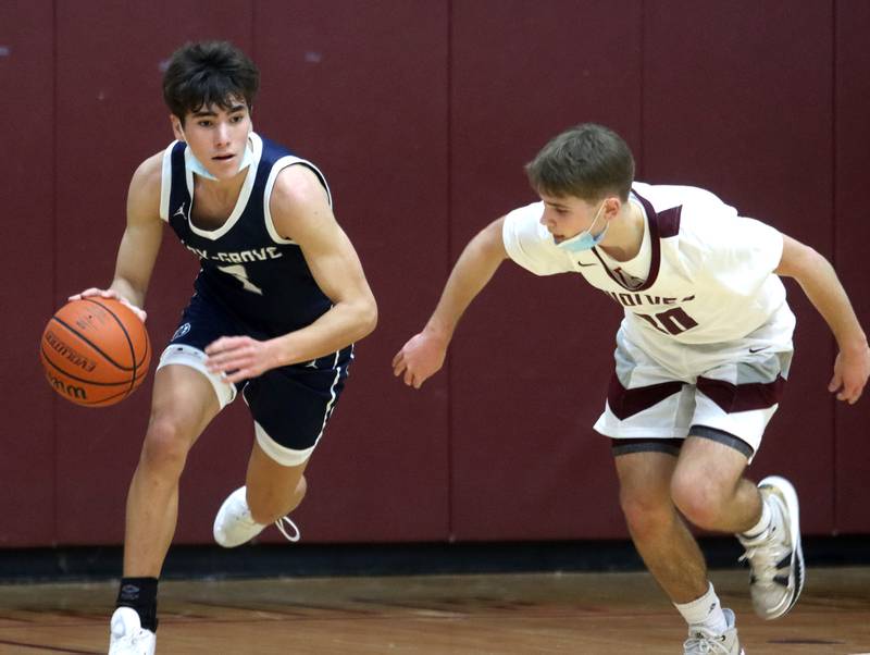 Prairie Ridge’s Jackson Otto, right, keeps pace with Cary-Grove’s John Mau during boys varsity basketball action in Crystal Lake Tuesday night.