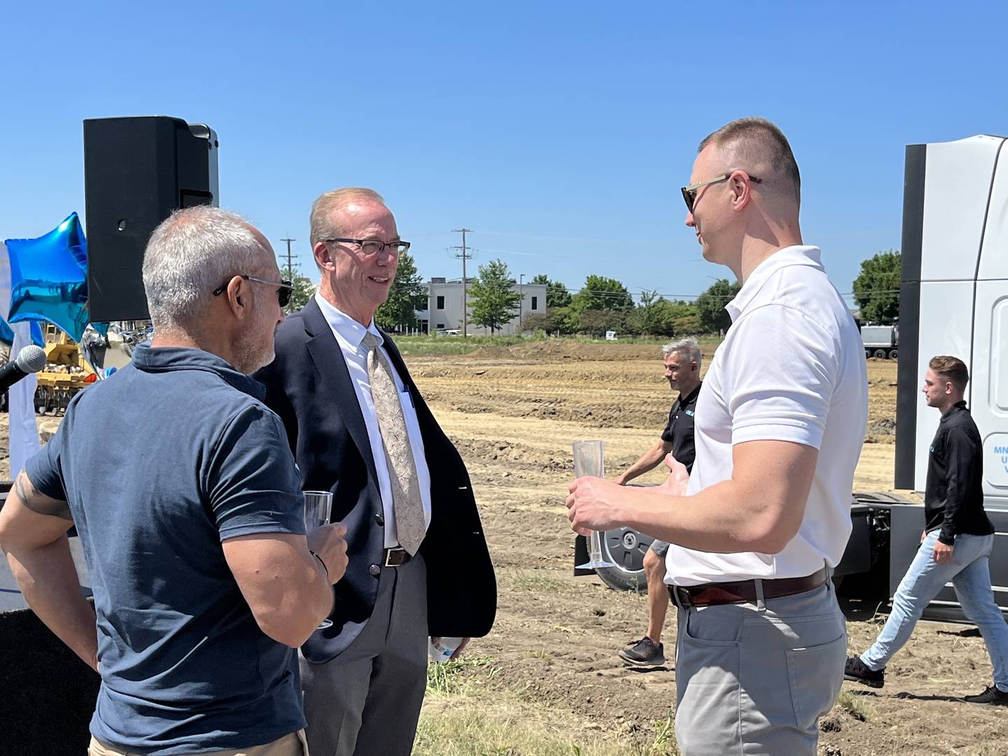 Plainfield Mayor John Argoudelis (left), Thomas Kenrich, Northern Builders chief financial officer, and Mark Narkys, owner and president of MNS1 Express, speak to each other after the groundbreaking ceremony for MNS1 Express’ new location in Plainfield on Thursday, July 14, 2022.