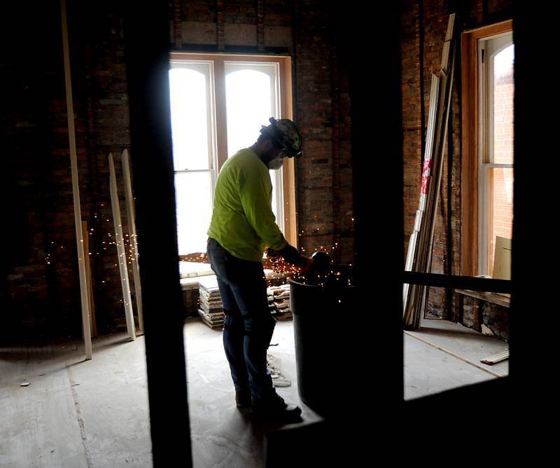 A worker from Bulley & Andrews, a Chicago-based contractor, works on removing trim work in the Old Courthouse and Sheriff’s House in Woodstock on Tuesday, March 1, 2022, as the renovation of the building continues.