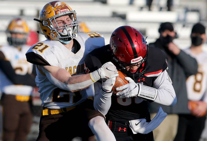 Huntley's Alex Dennison, right, hauls in the pass ahead of Jacobs' Ben Ludlum during their season opening football game at Huntley High School on Friday, March 19, 2021 in Huntley.
