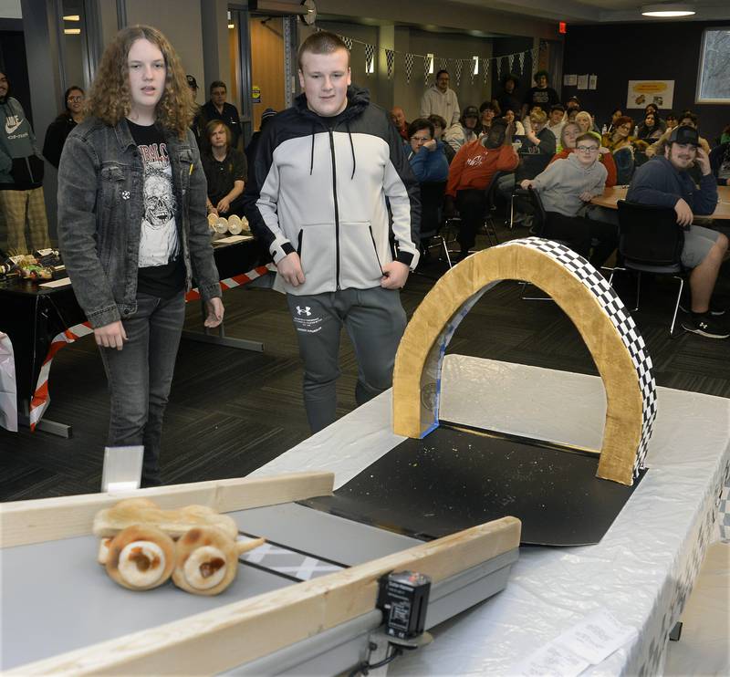 Keegan Gromm and Christian Gray, of Ottawa High School, watch as their edible car rolls toward the finish line Wednesday, Feb. 22, 2023, at the 18th annual Edible Car Contest at Illinois Valley Community College.