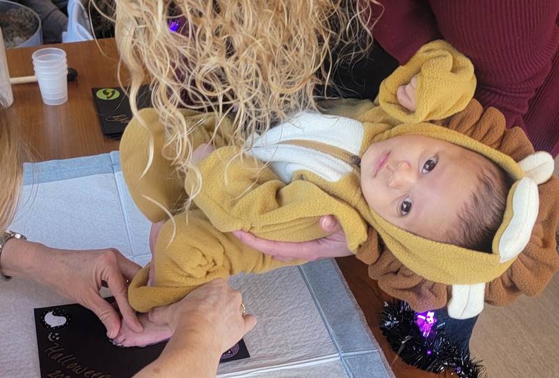 Elijah Kelley, 1 month, of Lake in the Hills, gets his foot printed at the Advocate Baby Bistro Halloween party in October 2024.