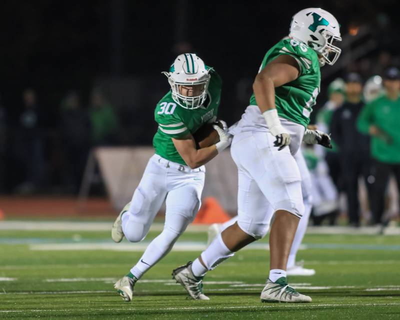 York's Jake Melion (30) runs behind Ellis McAdoo (65) during Class 8A Playoff football game between Oswego East at York.  Oct 28, 2022.