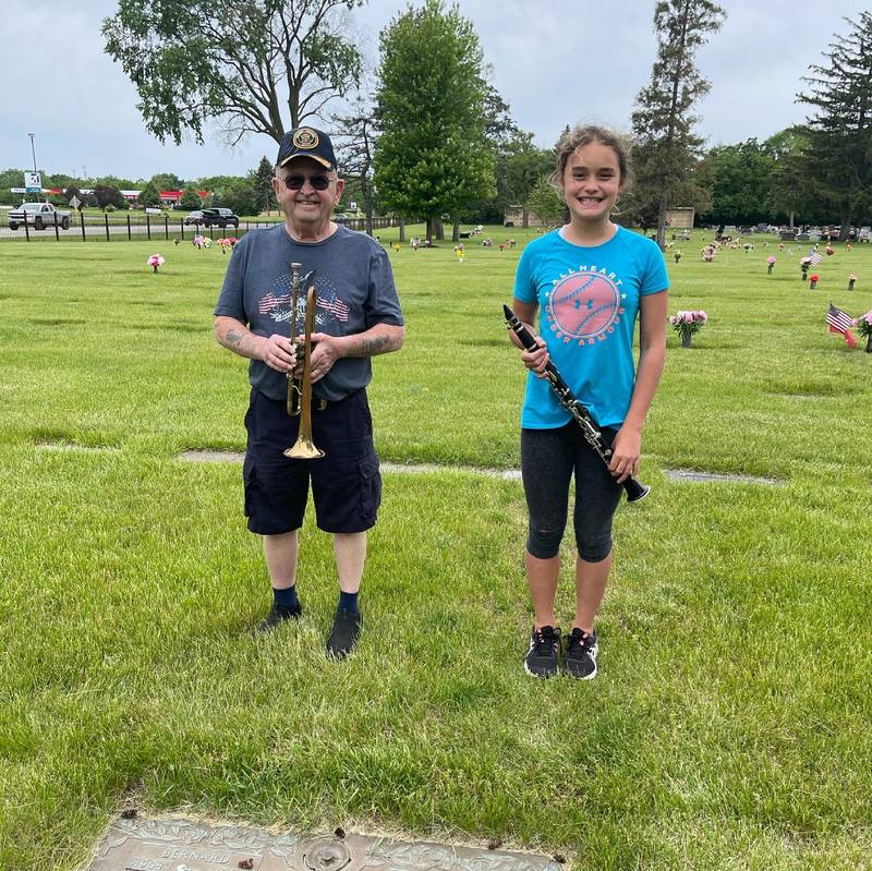 James McElroy of Morris is seen with his granddaughter Madelyn McElroy in 2021 when they both participated in taps Across America at Woodlawn Memorial Park in Joliet. James played taps on his bugle; Madelyn played taps on her clarinet.