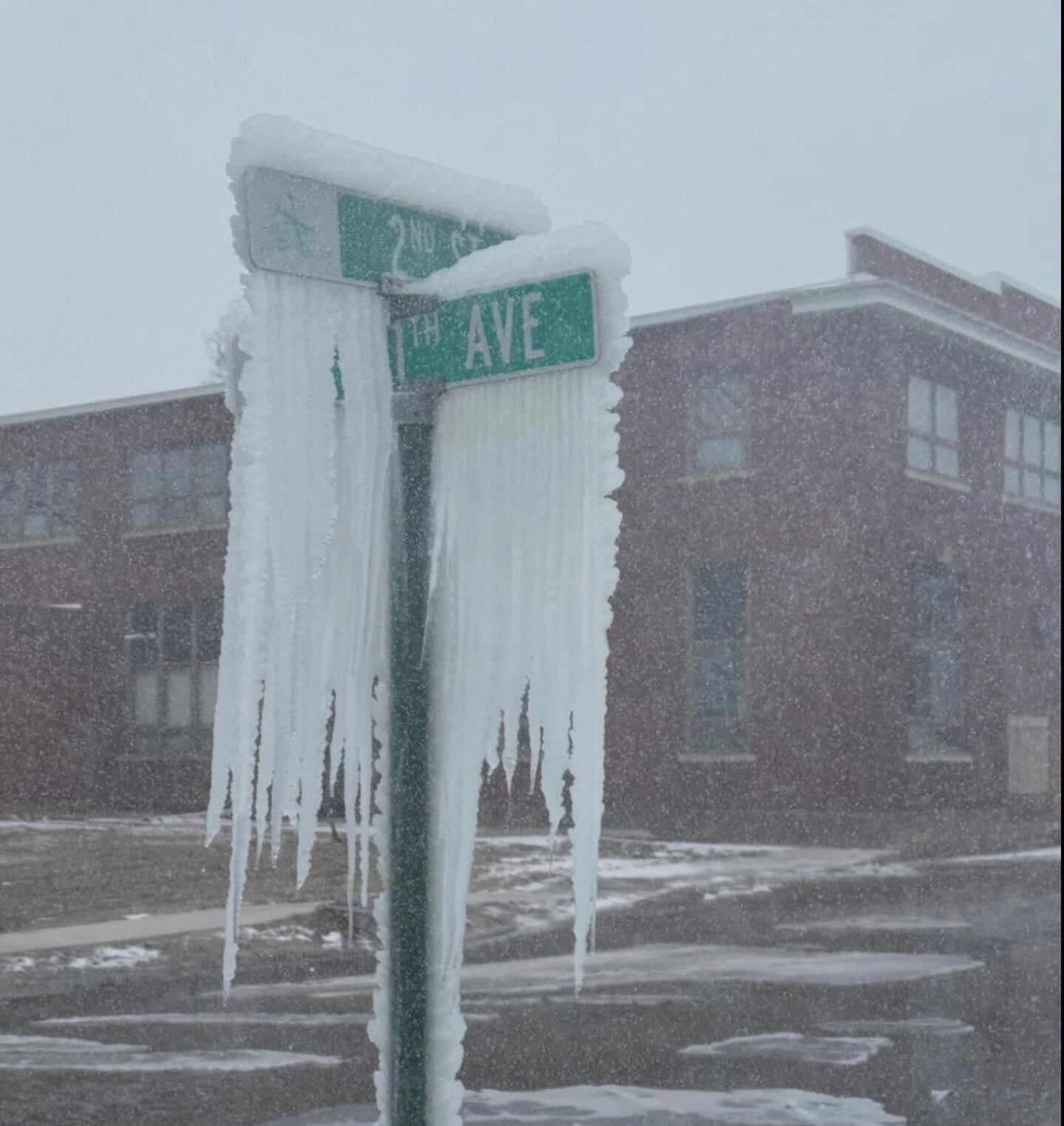 Ice hangs on a street sign Sunday near the scene of an apartment building fire in Fulton.