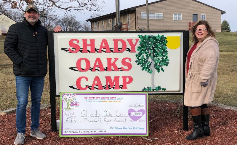 100+ Women Who Care Will County member Sheila Newcomb presents a check for $15,800 to Shady Oaks Camp Executive Director Scott Steele.