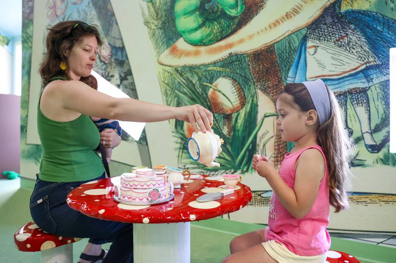 Sophie Angeles, 5, of Joliet, enjoys a tea party with her mom, Jill, and 1-month-old brother Vincent at the Exploration Station's new Storybook Forest exhibit on Monday, June 23, 2025, during its grand opening event.