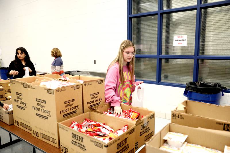 Downers Grove South High School freshman Olivia Mickus packs bags of food as part of the Blessings in a Backpack program on Monday, Nov. 13, 2023. The program will provide meals for 200 food insecure students in Downers Grove Grade School District 58 who won't have access to school meals during the upcoming Thanksgiving break.