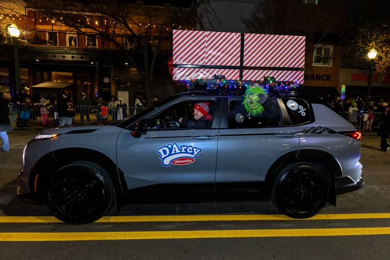 The Grinch, in a D’Arcy Automobiles car, waves to spectators during the Light Up the Holidays Parade in Downtown Joliet on Nov. 28, 2025.