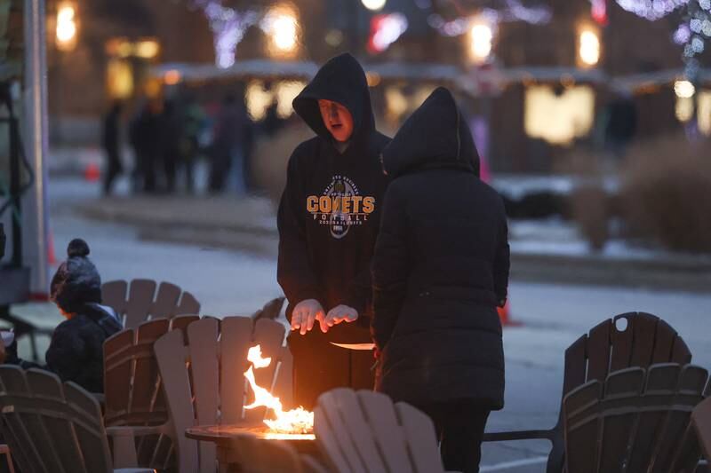 Scott Coronelli warms up at a fire pit at New Lenox’s Christmas in the Commons.