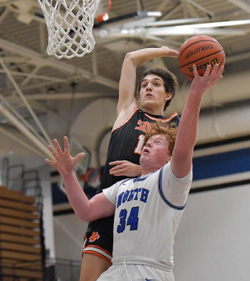 St. Charles North's Jake Furtney (34) takes a shot against Wheaton Warrenville South Nick Brooks (15) during a game on Friday, December 2, 2022.