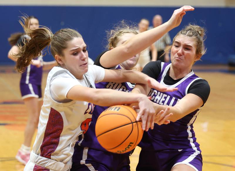 Genoa-Kingston's Sydney Hansen, (left) Rochelle's Abby Metzger and Rochelle's Payton Cesarone (right) go after a loose ball during their game Monday, Dec. 16, 2024, at Genoa-Kingston High School.