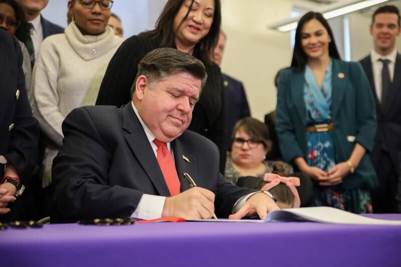 Gov. JB Pritzker signs the Dignity in Pay Act at a ceremony in Chicago on Tuesday, Jan. 21, 2025.