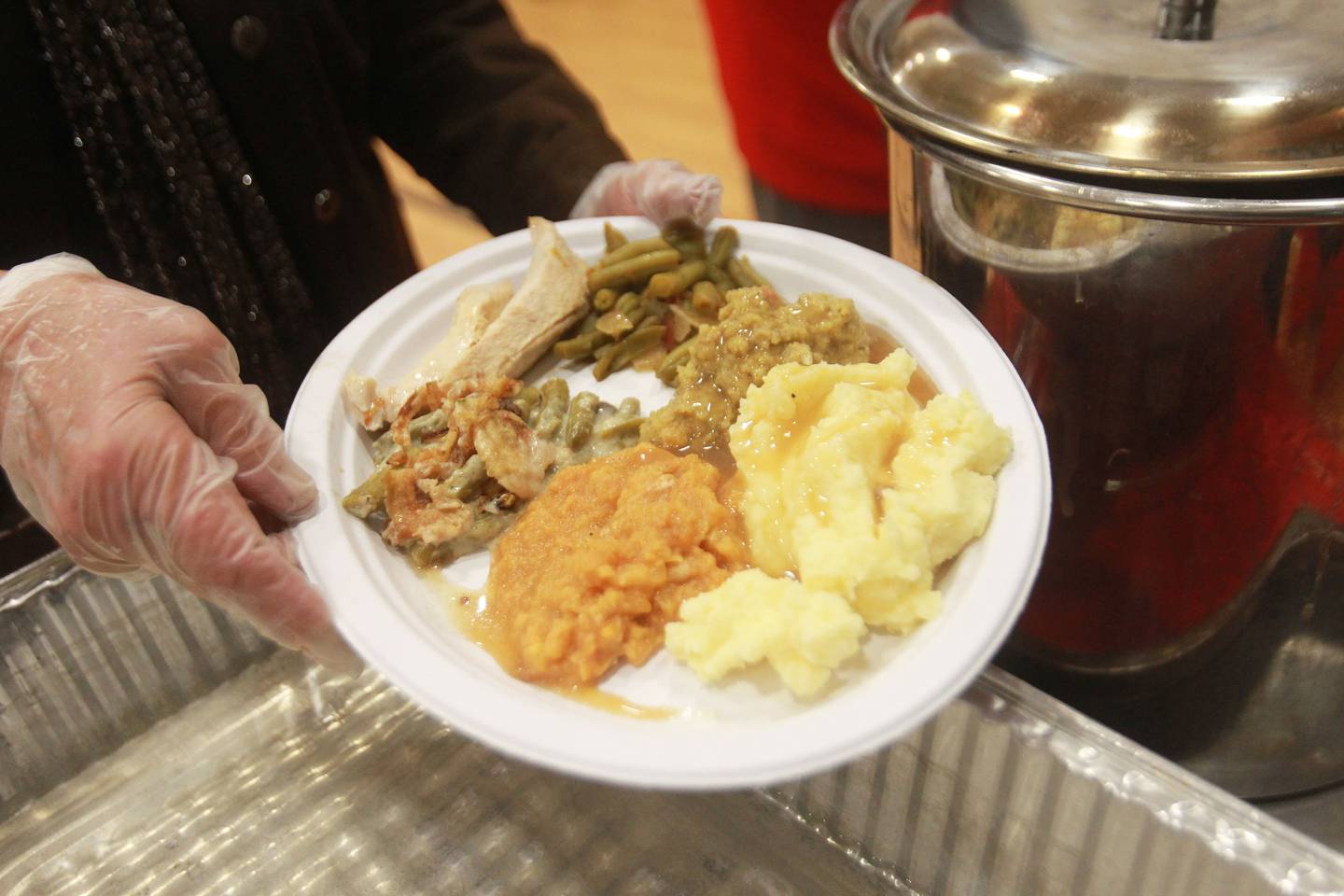 Judy Martini, Grant Township clerk, holds her own Thanksgiving plate after serving others during the 2nd Annual Fox Lake Community Thanksgiving Dinner at Lakefront Park in Fox Lake. Tanya and Tim Hill, of Fox Lake, Kim Lunstrom, of Grayslake and other volunteers and community leaders helped to prepare and serve the dinner.