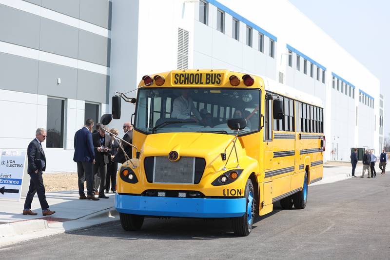Members of the media and government officials test drive the new all electric bus during a press conference and interactive tour the new manufacturing facility.. Monday, Mar. 21, 2022, in Joliet.