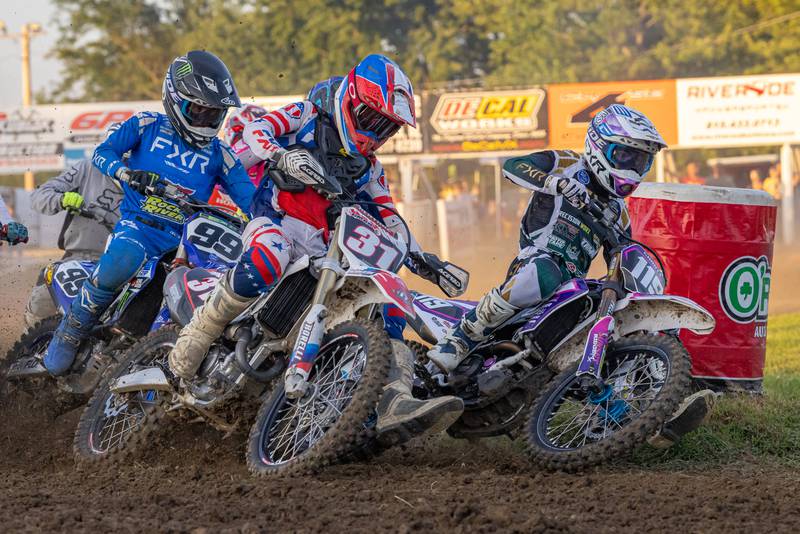 Racer Austin Hanabarger (right) races neck and neck with Garrett Ward (center) to the holeshot marker at Megacross at the Tri County Fair on August 30, 2025 in Mendota.