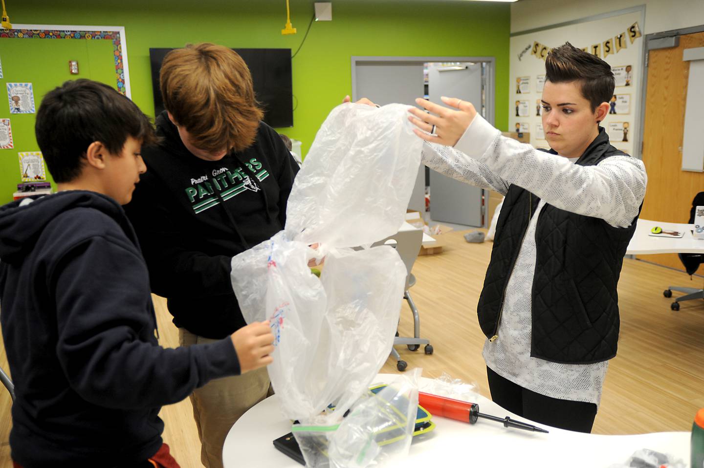 STEM teacher Bethany Bellavia, right, works with Prairie Grove Middle School seventh graders, Anthony Moran, left, and Kal Click and as they work on making a parachute during a Flight and Space STEM class at the school on Tuesday, April 26, 2022.