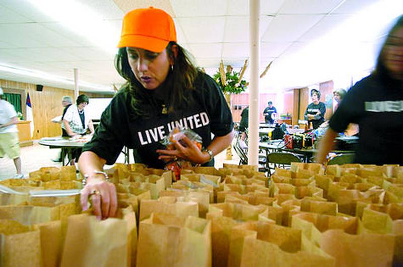 Jennifer Dallas adds items to lunch bags for the Let’s Feed Our Children program at a previous United Way of Whiteside County campaign kickoff event.