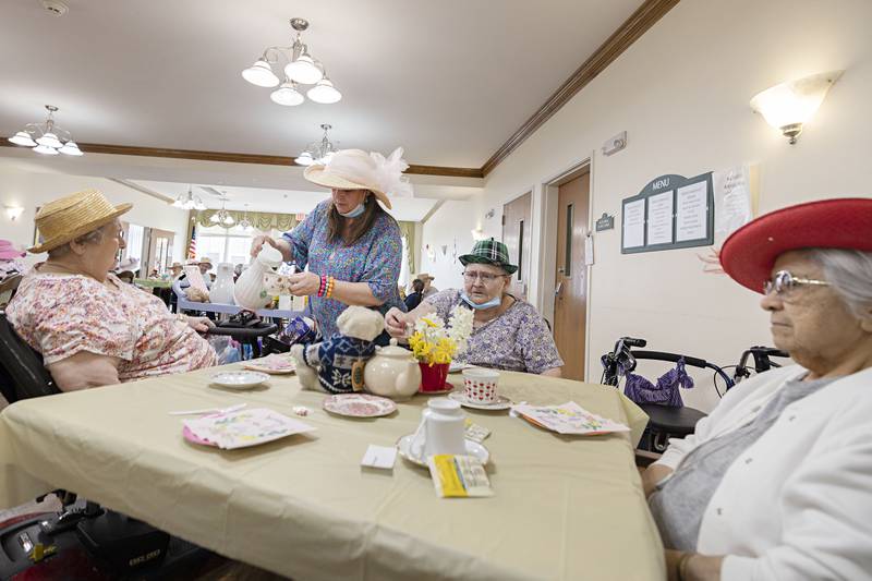 Rae Higly, resident services coordinator at Heritage Woods pours tea for Geraldine Rusted (left), Debra Hartman and Hope Contreras Friday, March 31, 2023.