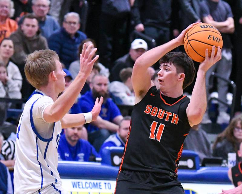 Wheaton Warrenville South's Zach Rogers (11) looks for an open teammate during the game on Friday Feb. 6, 2026, while being defended by Wheaton North's Henry Schlickman (1) held at Wheaton North High School.