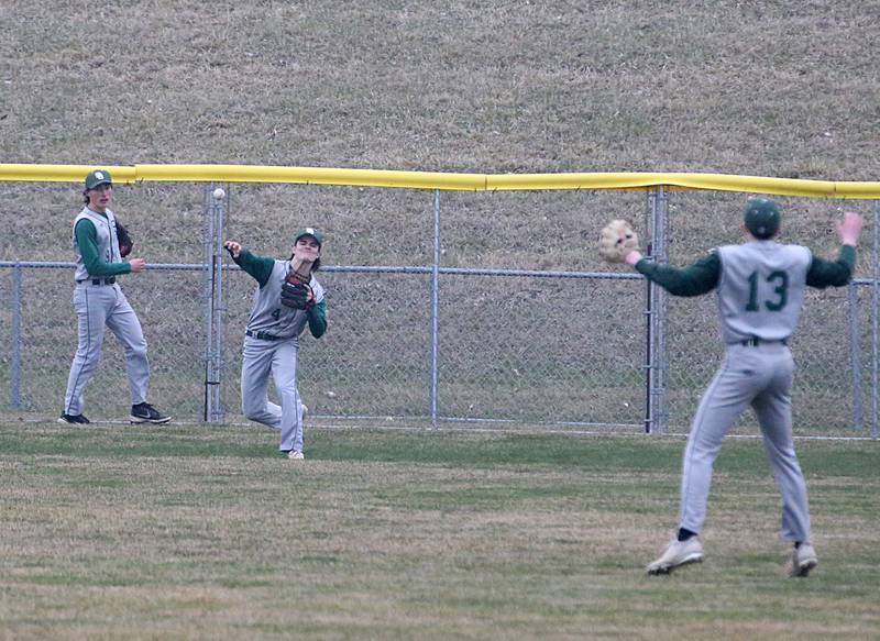 St. Bede's John Brady (middle) throws to his teammate Alex Ankieicz (right) after fielding a deep hit ball while his other teammate Ryan Slingsby (left) assists during a game against Ottawa on Wednesday, March 22, 2023 at Ottawa High School.