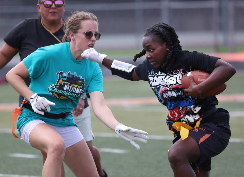 DeKalb’s Kaylee Tenard runs the ball after an interception as Sarah Foltz goes for her flag Wednesday, Aug. 20, 2025, during the first practice of the DeKalb High School flag football team. The squad is preparing for their inaugural season.