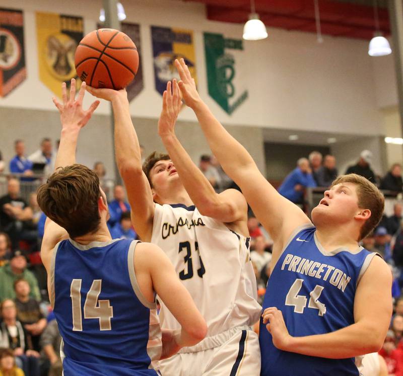 Marquette's Caden Eller (center) attemps to get a shot off as Princeton's Grady Thompson (left) and Bennett Williams (right) defend during the Colmone Classic tournament on Friday, Dec. 9, 2022 at Hall High School in Spring Valley.
